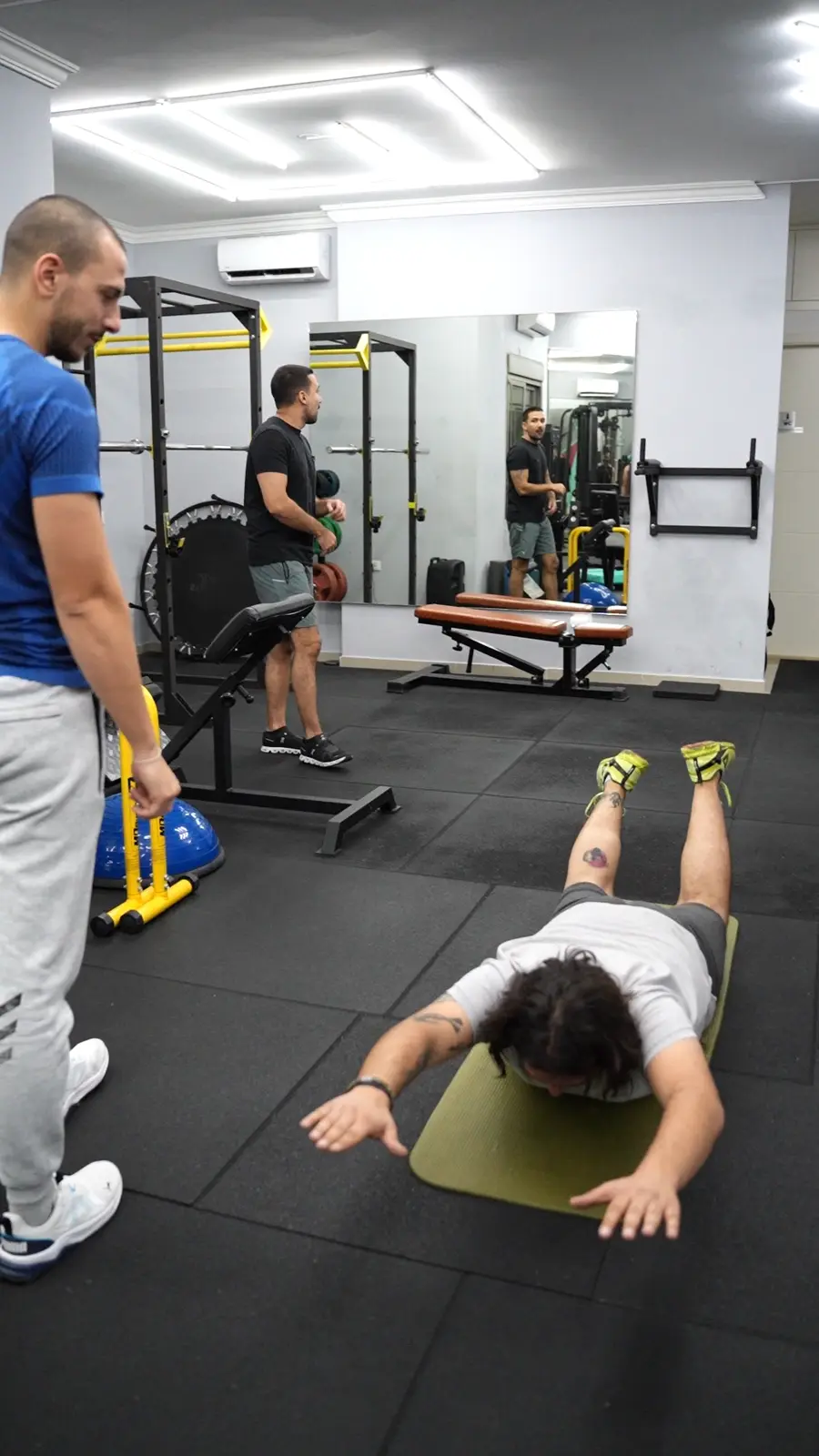 A coach watching a client's form during an exercise